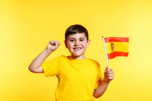 Ein junger Junge hält eine spanische Flagge und lächelt beliebte spanische Jungennamen